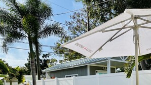 Zona de piscina con sillones, una bañera de hidromasaje y una mesa de comedor con sillas.