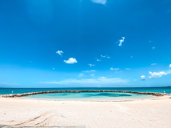 A beach with clear blue sky and turquoise sea.