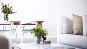 Una sala de estar moderna con un sofá, una mesa de centro y una zona de comedor con sillas y una mesa.