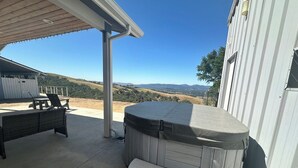A hot tub with steps, a bench, and a covered patio area with a view of hills. - Close to Wineries/Hot Tub/Vineyard View/Dog Okay! (Templeton)