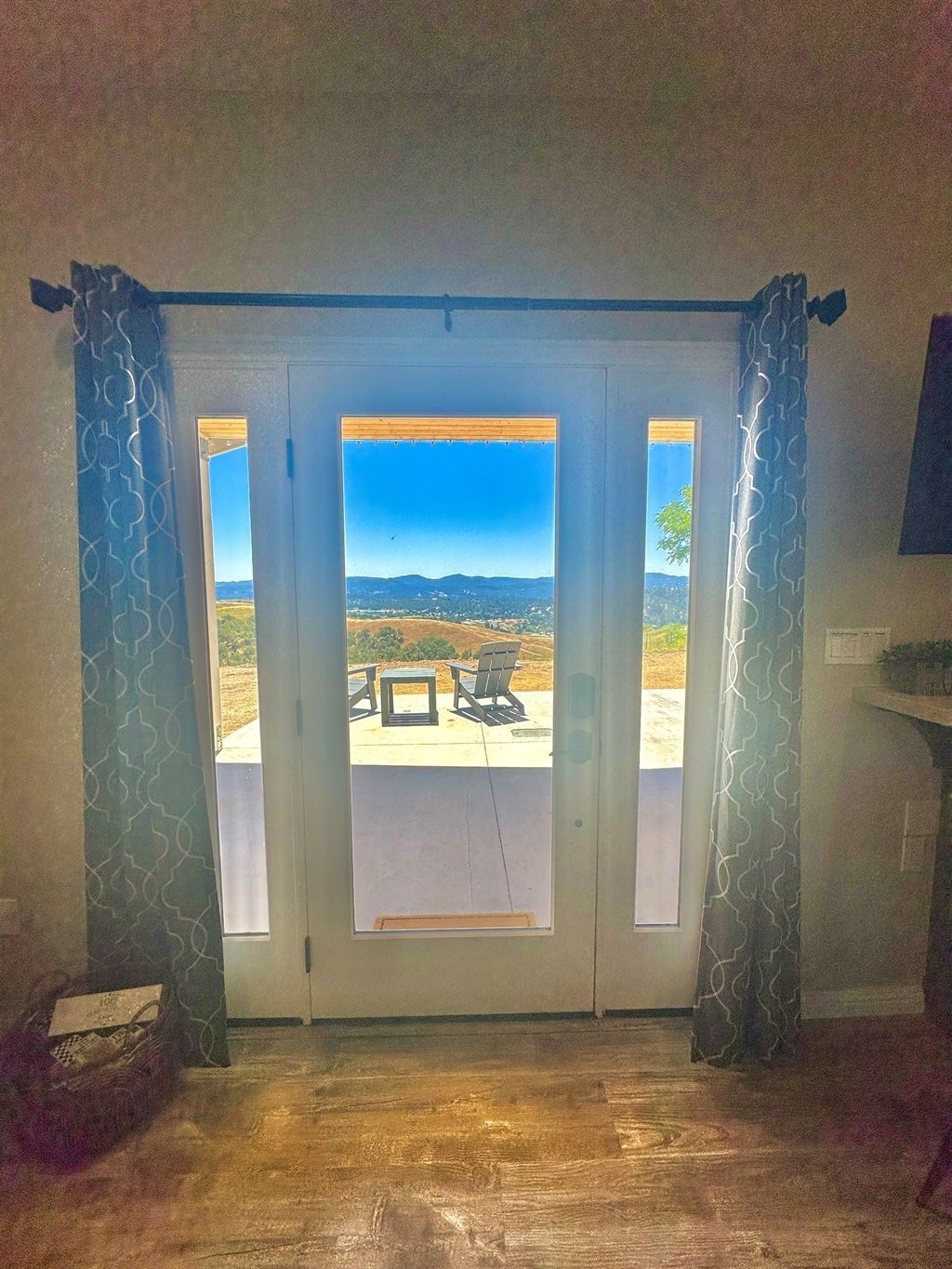 Une pièce dotée d’une porte-fenêtre coulissante donnant sur un patio extérieur avec une table et des chaises.