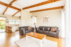 Ein Wohnzimmer mit einer Couch, einem Couchtisch und einem Essbereich mit Stühlen.