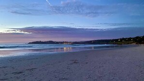 Una playa con cielo despejado y costa lejana.