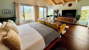 Un dormitorio con cama, televisor, escritorio y ventana.