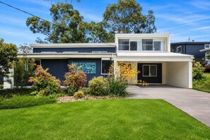 A modern two-story house with a covered driveway and a well-maintained front yard.