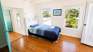 Un dormitorio con cama, ventana y puerta.