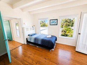 Une chambre à coucher avec un lit, une fenêtre et une porte.