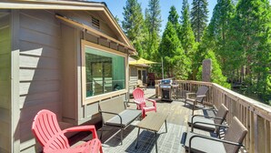 A deck with outdoor seating, a grill, and a view of a forest. - Cozy Retreat w/ Deck ~ 2 Mi to Pinecrest Lake! (Strawberry)