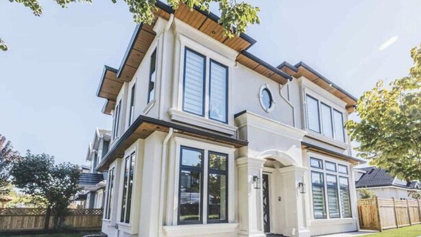 A two-story house with a front porch, large windows, and a well-maintained lawn. - Amazing 1 Bedroom suite in Vancouver (Vancouver)