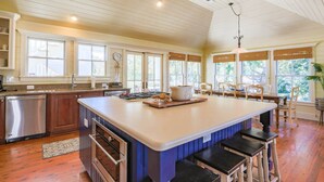 A spacious kitchen with a large island, wooden cabinets, and a built-in oven. - 3 Min Walk to Beach! Serene Retreat w/ Heatable Private Pool, Ping Pong Table, Multiple Decks & Dens (Isle of Palms)