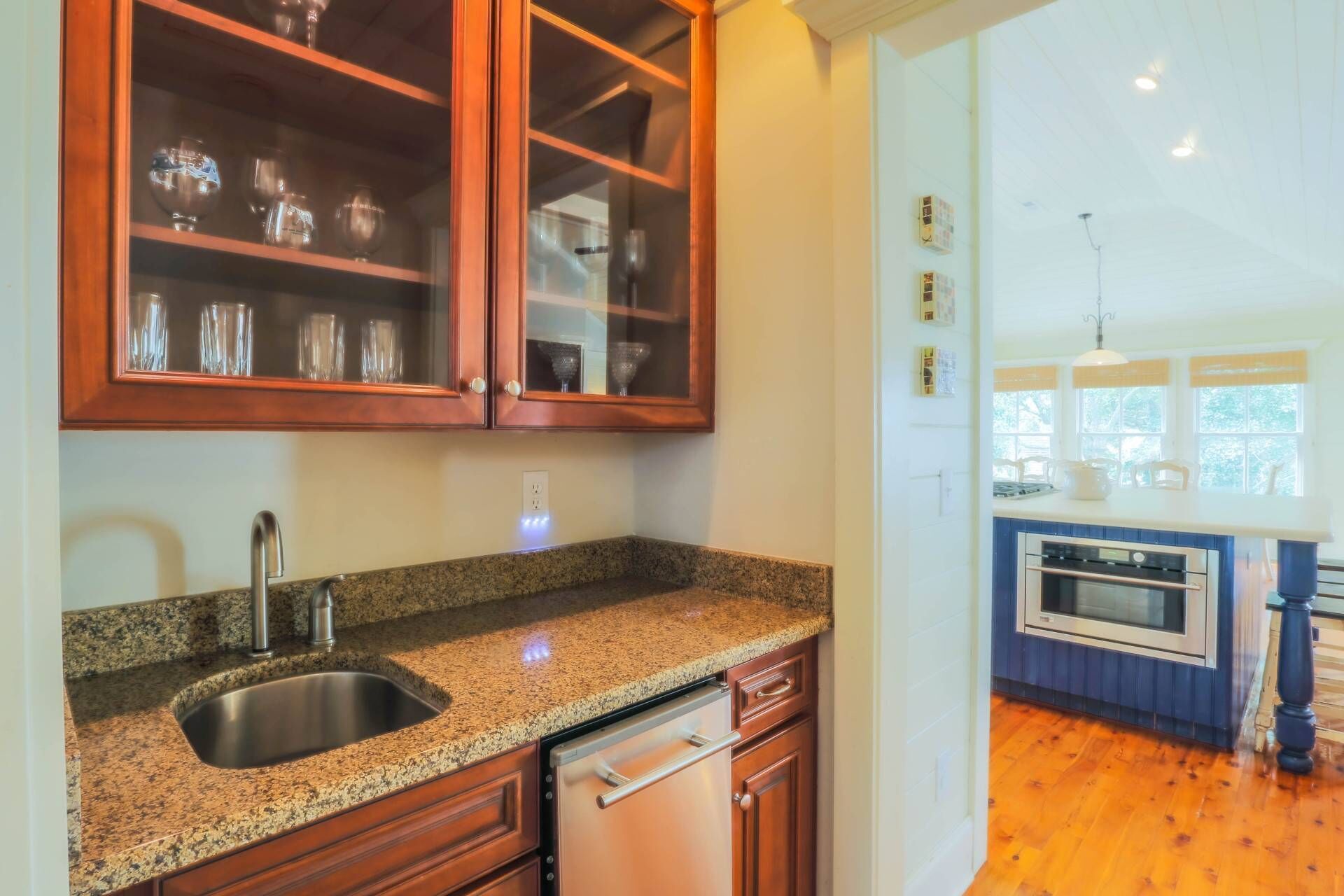 A kitchen with granite countertops, wooden cabinets, a stainless steel sink, and a dishwasher.