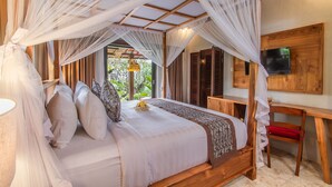 A bedroom with a canopy bed, a desk, and a TV. - D'Junas Villas by GenuineHost  (Ubud)