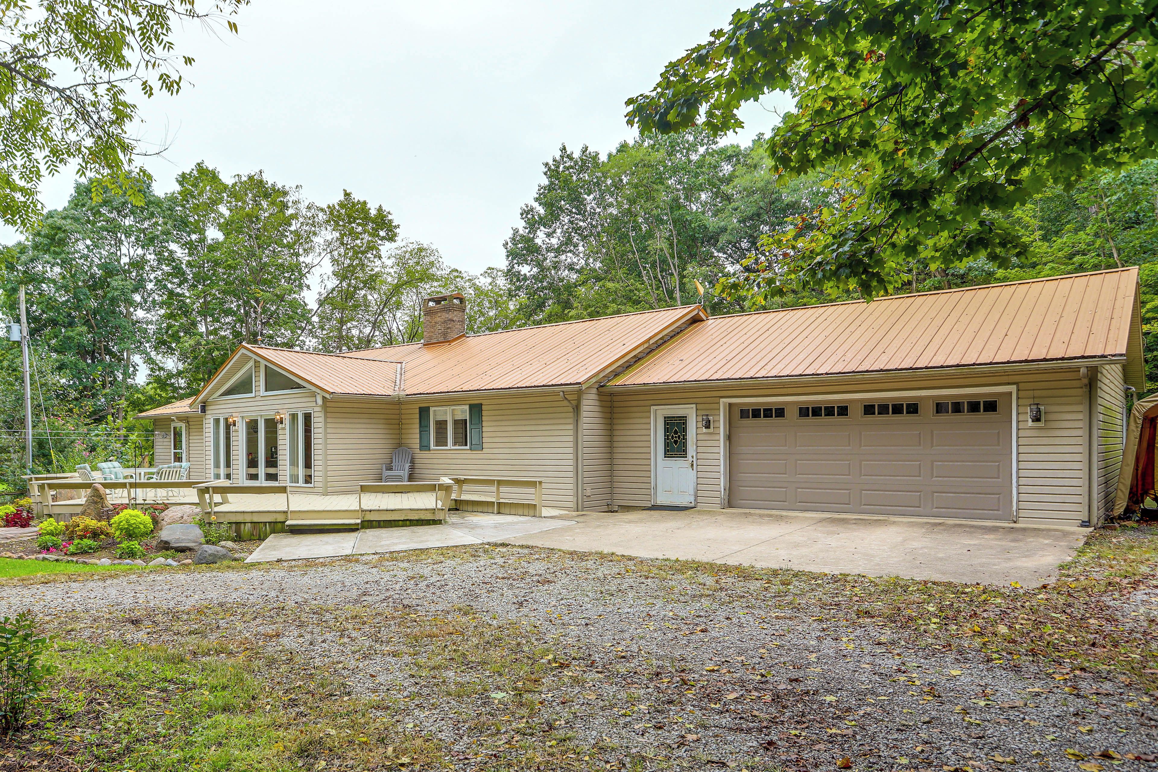 A two-story house with a front porch, a garage, and a covered patio area.