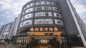A multi-story hotel with a modern design, featuring a prominent entrance with glass doors and a yellow carpet leading to the lobby. - Greentree Eastern Anshun Town Huangguoshu Avenue Jinhui Xindu Hotel (Anshun)