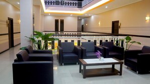 A modern lobby with a central seating area, a staircase, and a railing. - Rahat Icon Hotel (Tanjung Pandan)