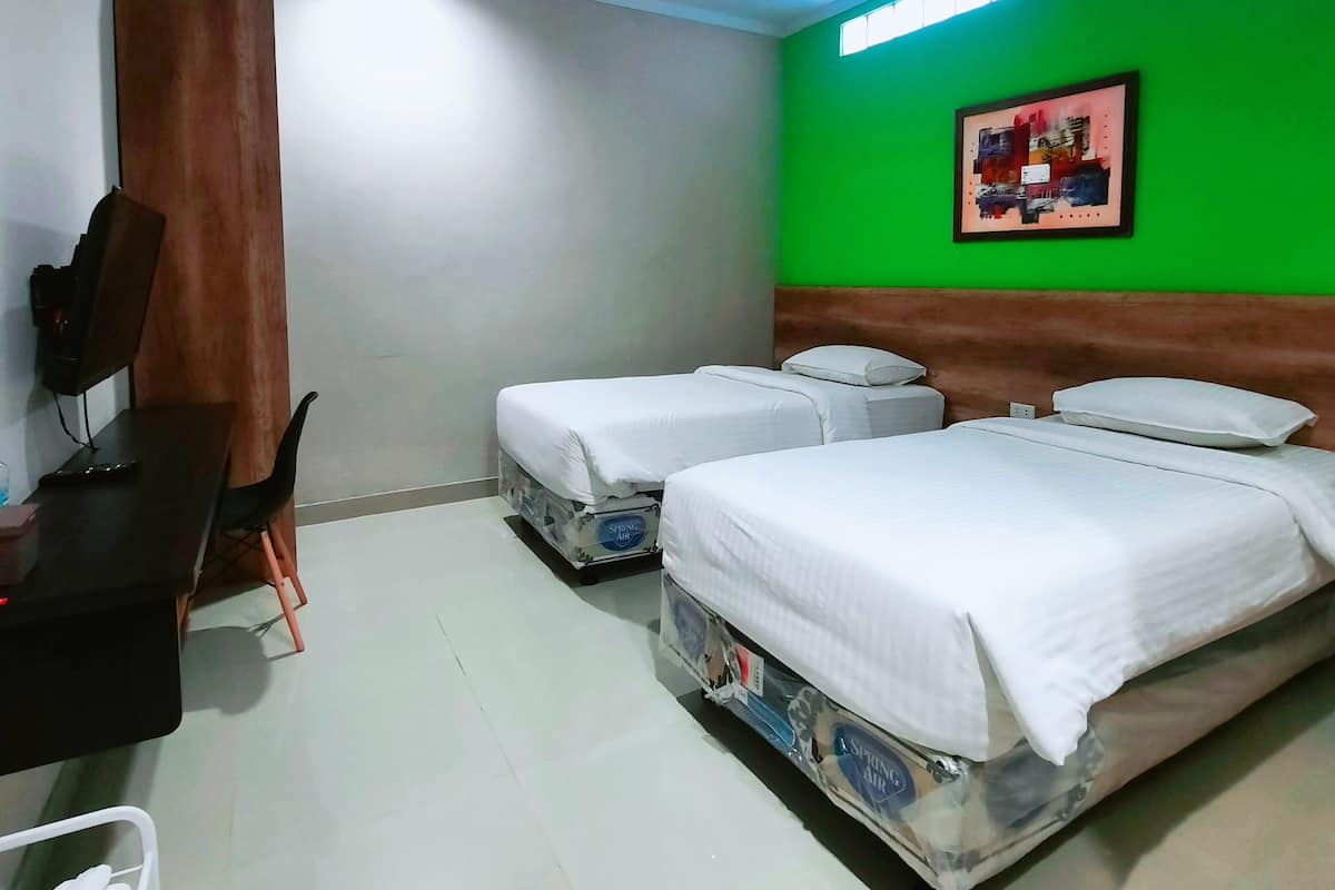 A hotel room with two beds, a desk, and a chair.