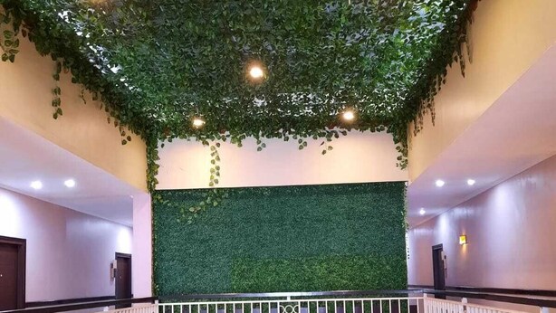 A multi-level interior with a green wall and a white railing. - Rahat Icon Hotel (Tanjung Pandan)