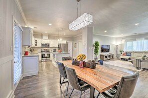 Enjoy a spacious open-plan living area with a central dining space, kitchen, and comfortable seating.