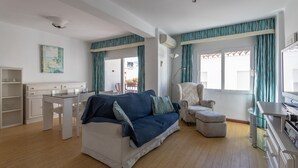 Un salon avec un canapé, un fauteuil et un bureau.