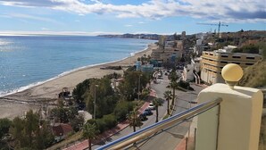 Eine Küstenstadt mit Strand, Gebäuden und wolkenlosem Himmel.