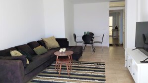 Ein modernes Wohnzimmer mit Sofa, Couchtisch und Fernseher-Lowboard.