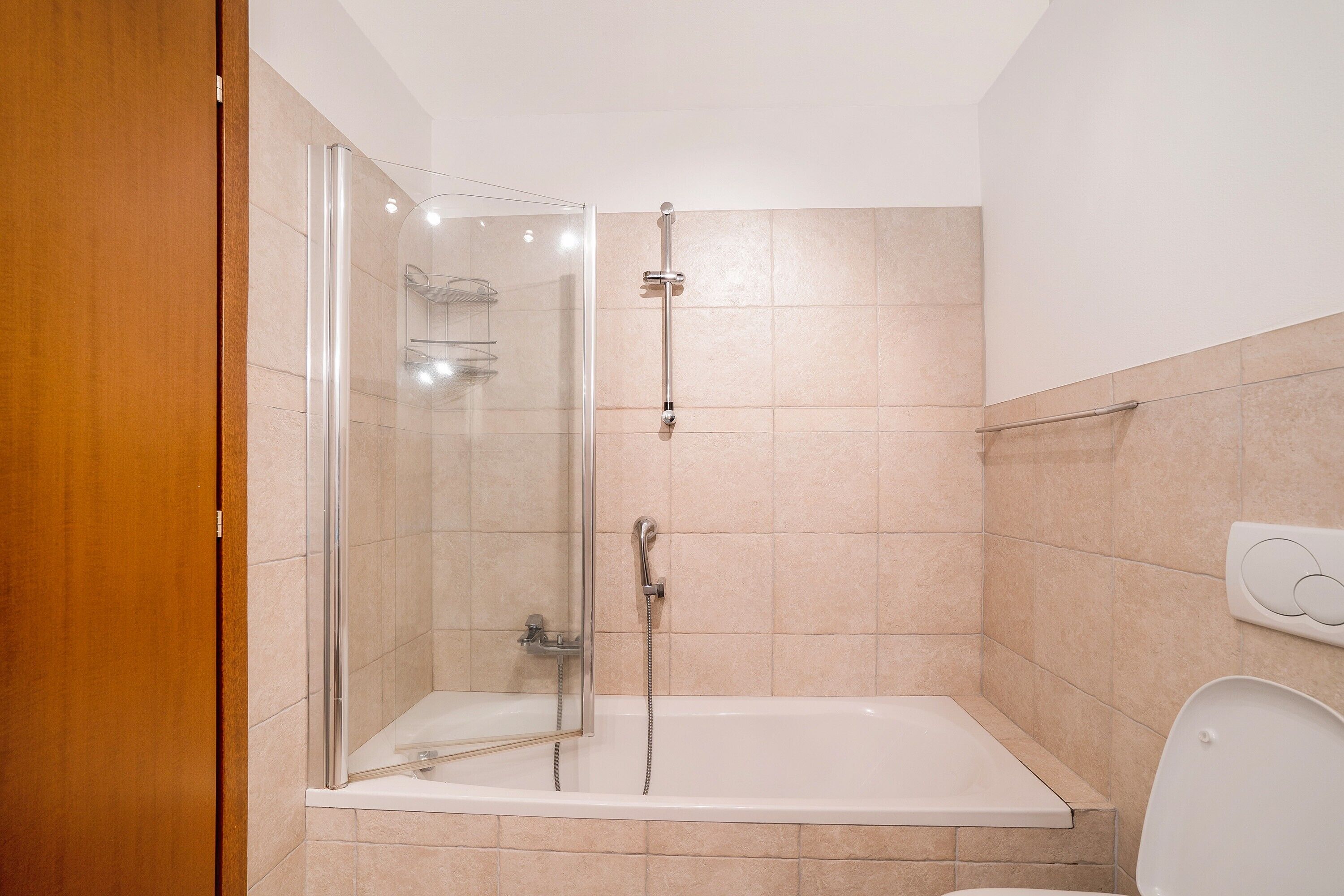 Un baño con ducha de vidrio, una bañera y un inodoro.