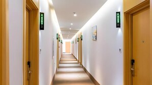 A hotel hallway with doors labeled with room numbers, a patterned carpet, and a ceiling with recessed lighting. - Greentree Alliance Beijing Shunyi District Xiaoying Hotel (Shunyi)