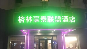 A hotel entrance with a neon sign in green and purple. - Greentree Alliance Beijing Shunyi District Xiaoying Hotel (Shunyi)