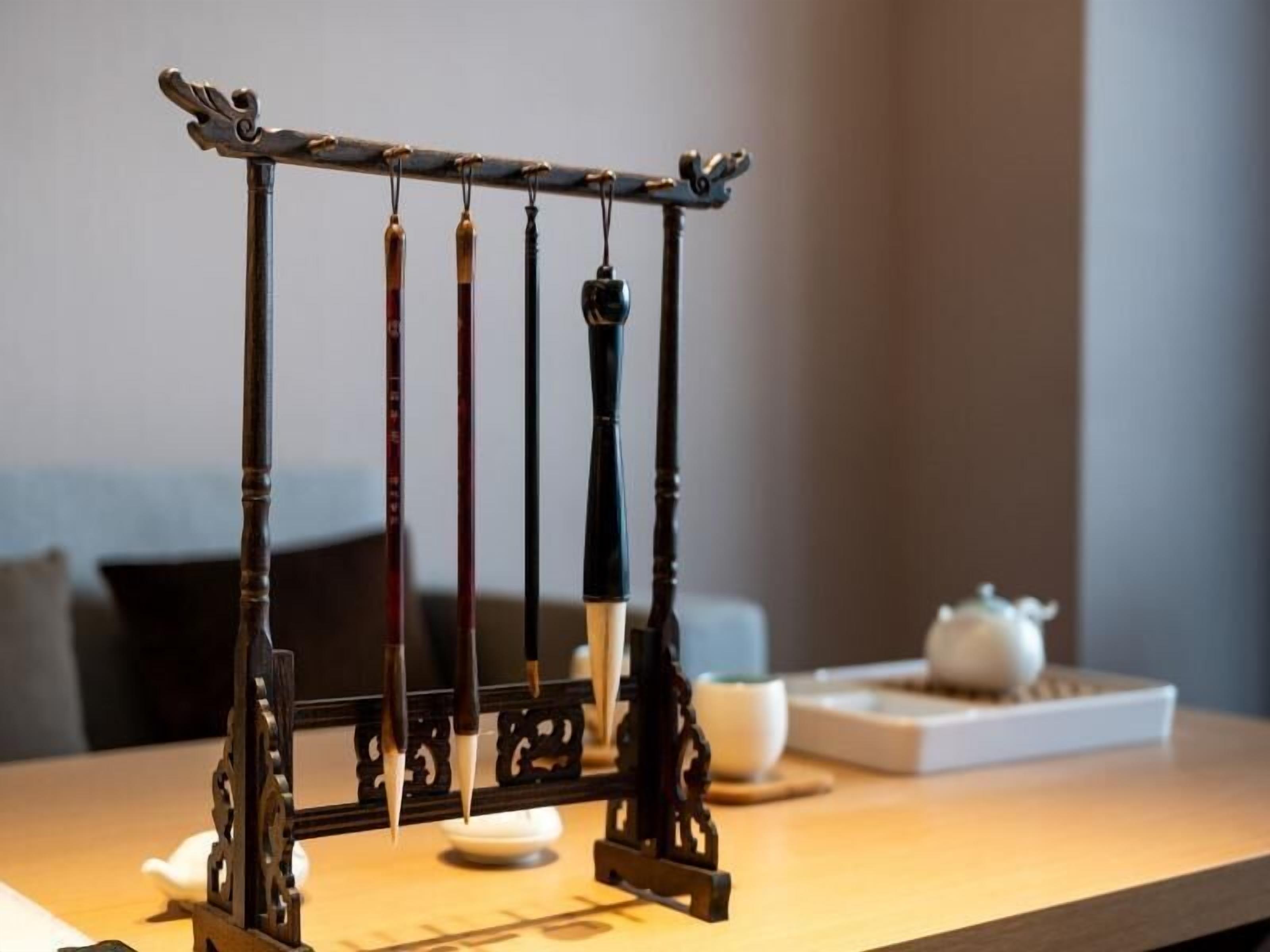 A traditional Chinese wind chime hanging on a wooden stand.