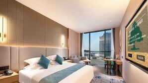 A modern hotel room with a large bed, a desk, and a view of the city. - Greentree Eastern Tongling City Beijing West Road Big Dipper City Hotel (Tongling)