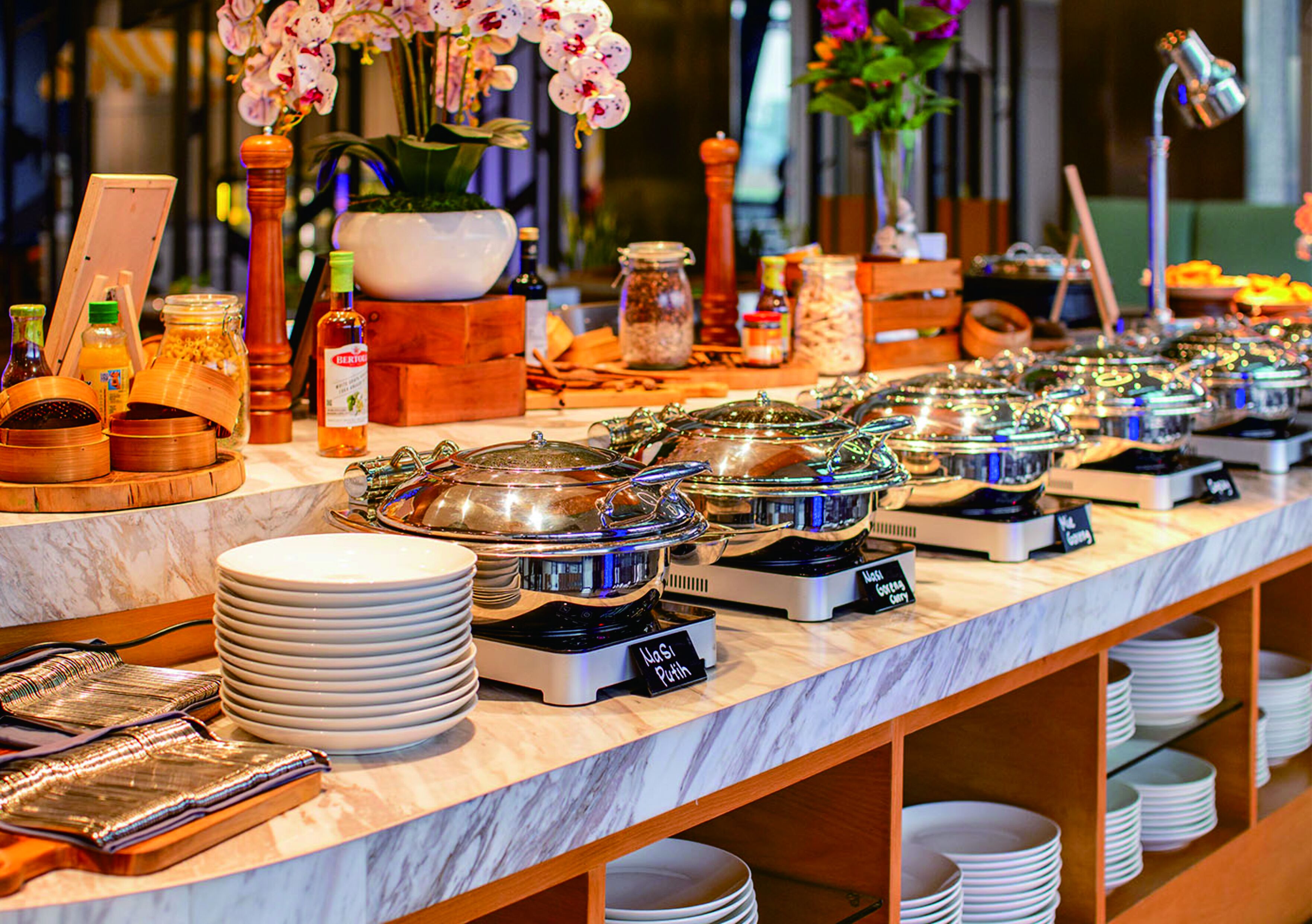 A buffet setup with various food stations labeled, including "Pork Chops" and "Pork Tenderloin."