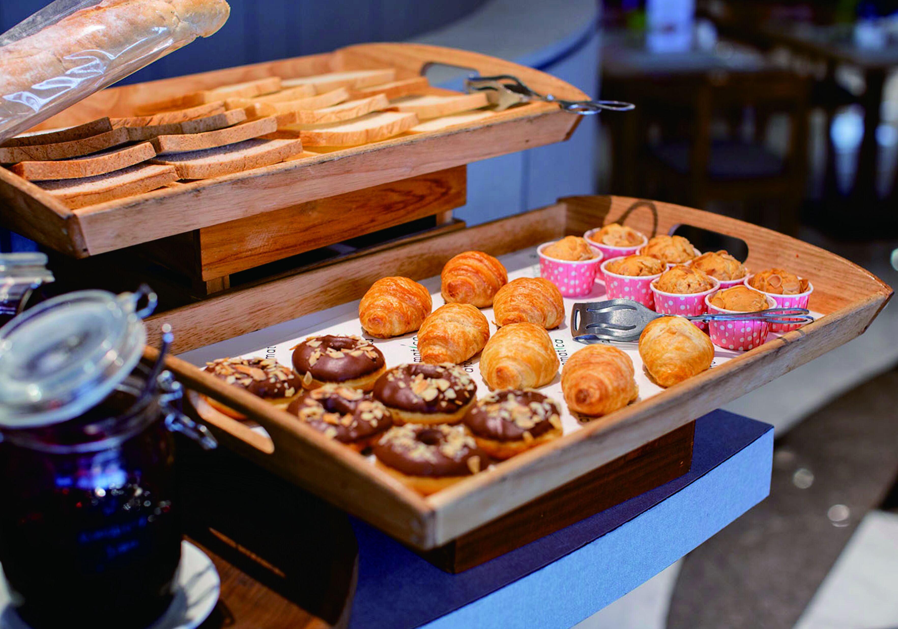 A buffet with various pastries and bread.