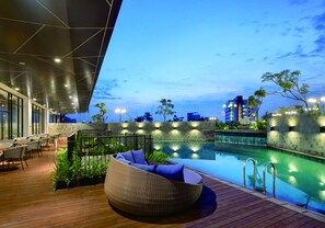 A rooftop pool area with a lounge chair, outdoor seating, and a view of the city skyline. - THE 1O1 Jakarta Airport CBC (Tangerang)