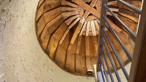 Eine Wendeltreppe aus Holz mit Metallgeländern, die nach oben führt.