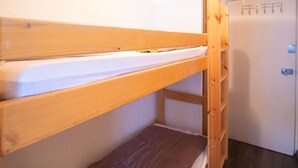 Een stapelbed met houten frame en matras.