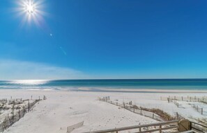 A beach with a wooden boardwalk leading to the water, clear skies, and a bright sun. - Quaint Gulf Front Condo | Leeward II Unit 5 | Seag (Santa Rosa Beach)