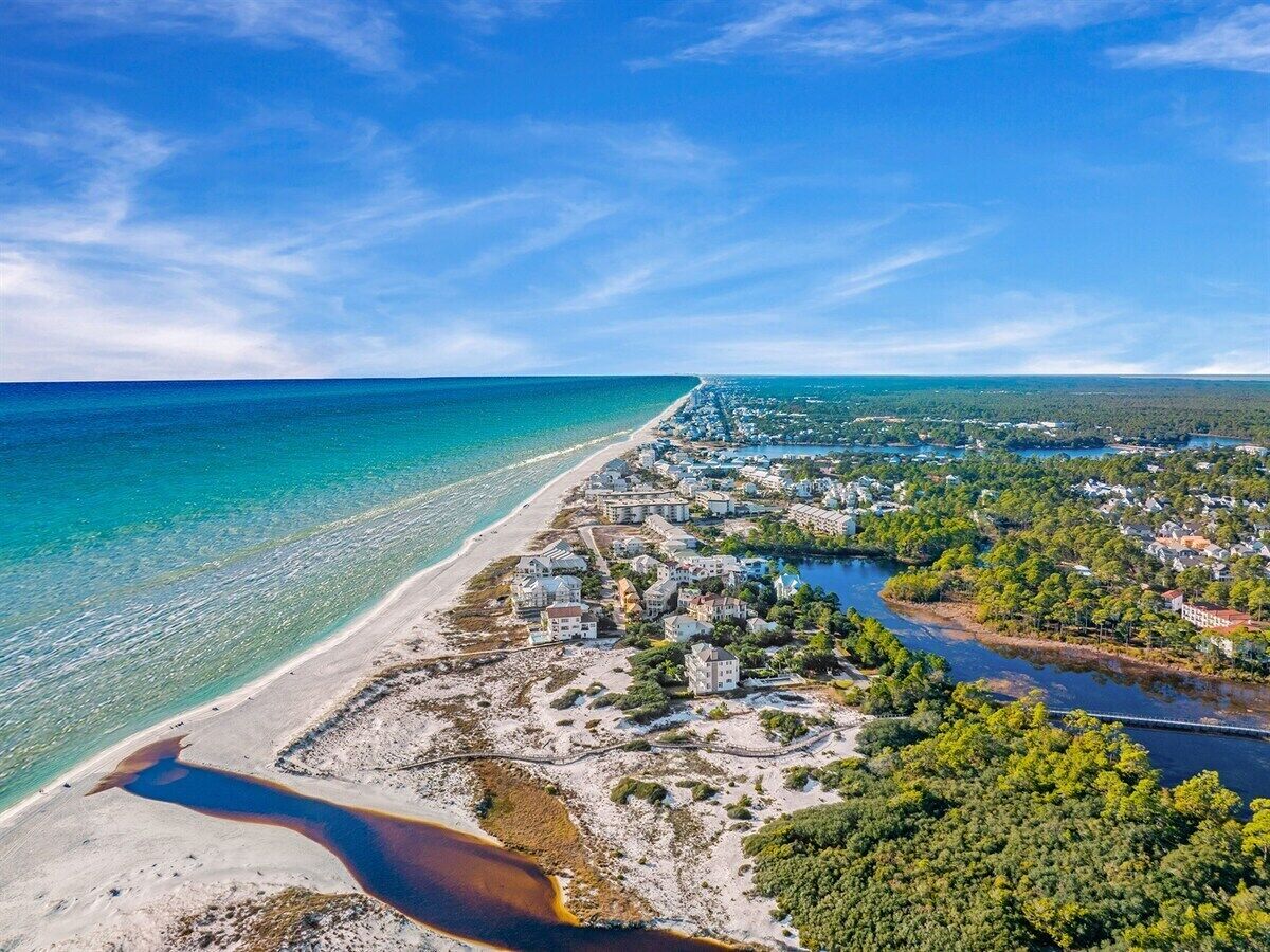 A coastal town with a beach, houses, and a river.