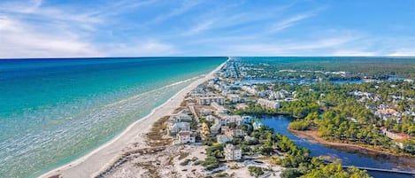 A coastal town with a beach, houses, and a river.