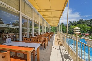 A restaurant with outdoor seating overlooking a pool. - Hotel Gloria - All Inclusive (Varna)