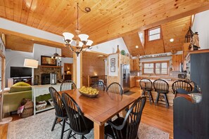A cozy wooden interior with a dining area, kitchen, and living space.