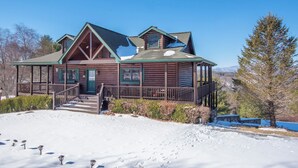 A log cabin with a porch, a staircase, and a view of the surrounding landscape. - Sweeping Mountain Views | Wraparound Decks | Cloud Rise (Piney Creek)