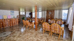 A dining area with wooden furniture and a stone wall backdrop. - Esmeralda Butik Hotel (Manavgat)