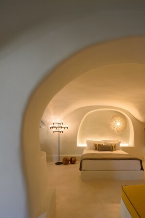 Une chambre à coucher avec un lit, une lampe de sol et un luminaire décoratif au plafond.