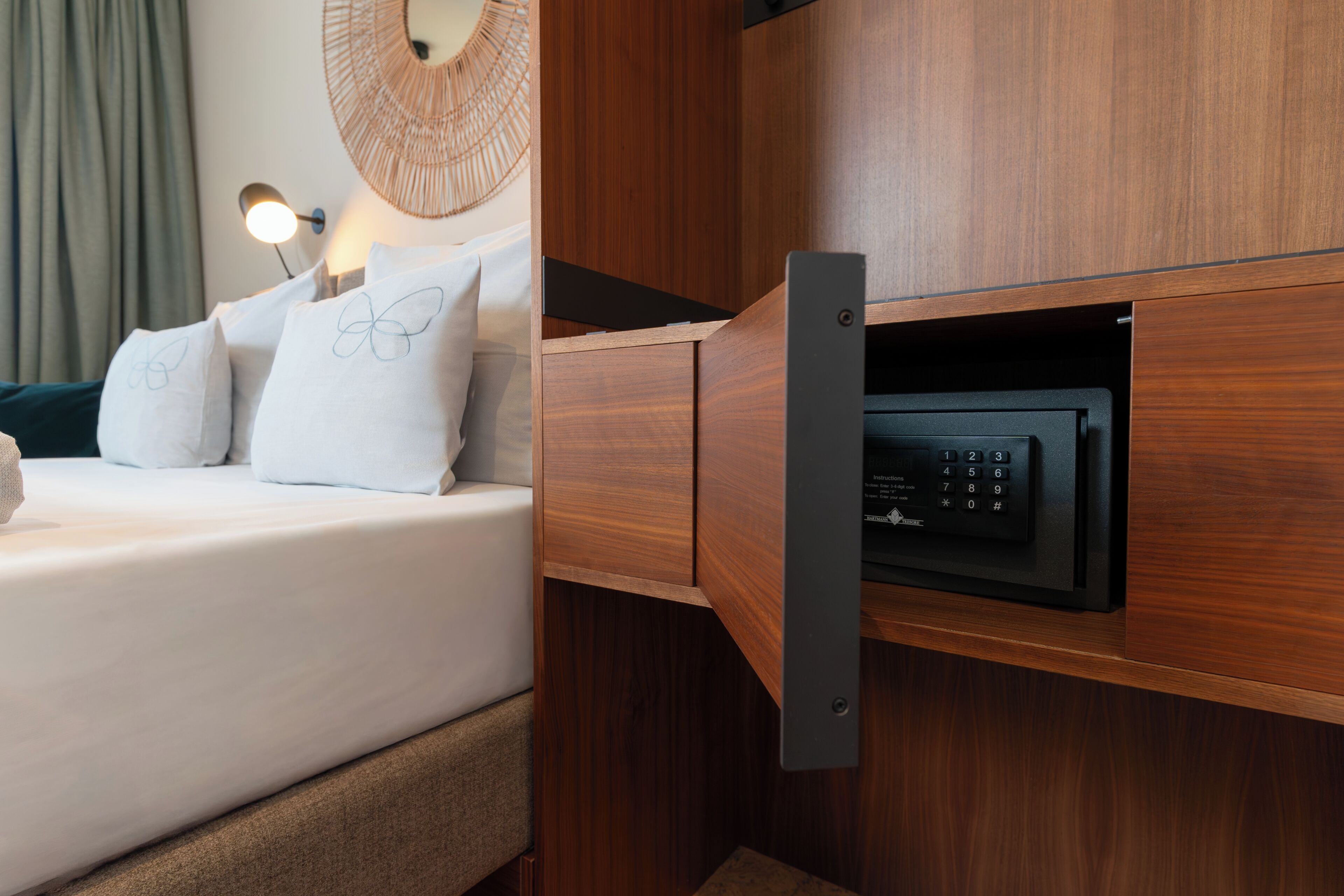 Une chambre d’hôtel équipée d’un lit, d’oreillers, d’une lampe de chevet et d’un four à micro-ondes intégré.