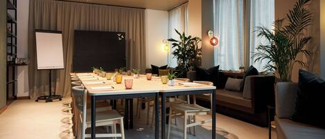 A modern living room with a dining area, a projector screen, and a sofa.