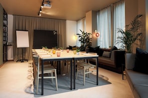 Una sala moderna con comedor, pantalla de proyector y sofá.