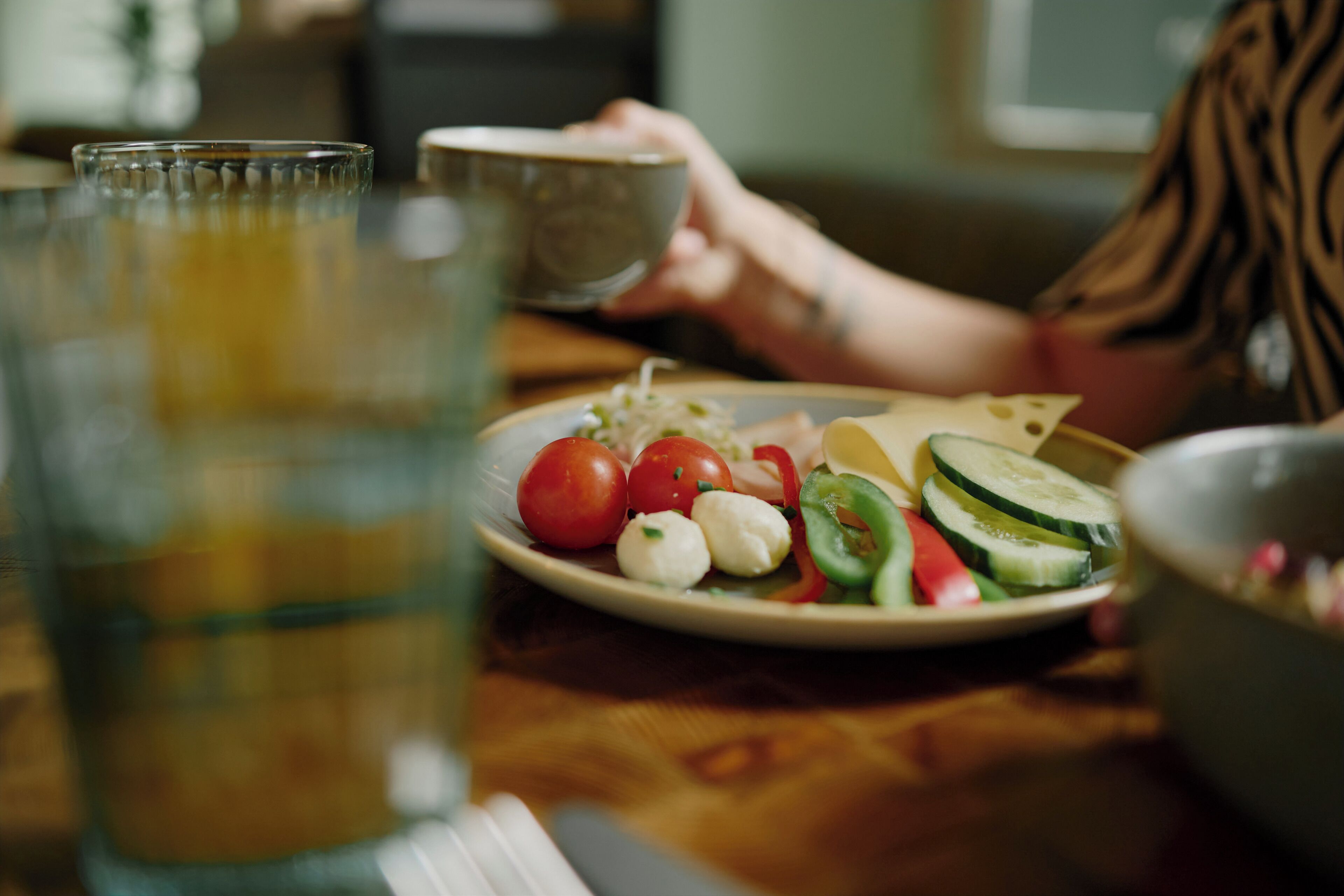A dining table with a plate of food, a glass of water, and a bowl.