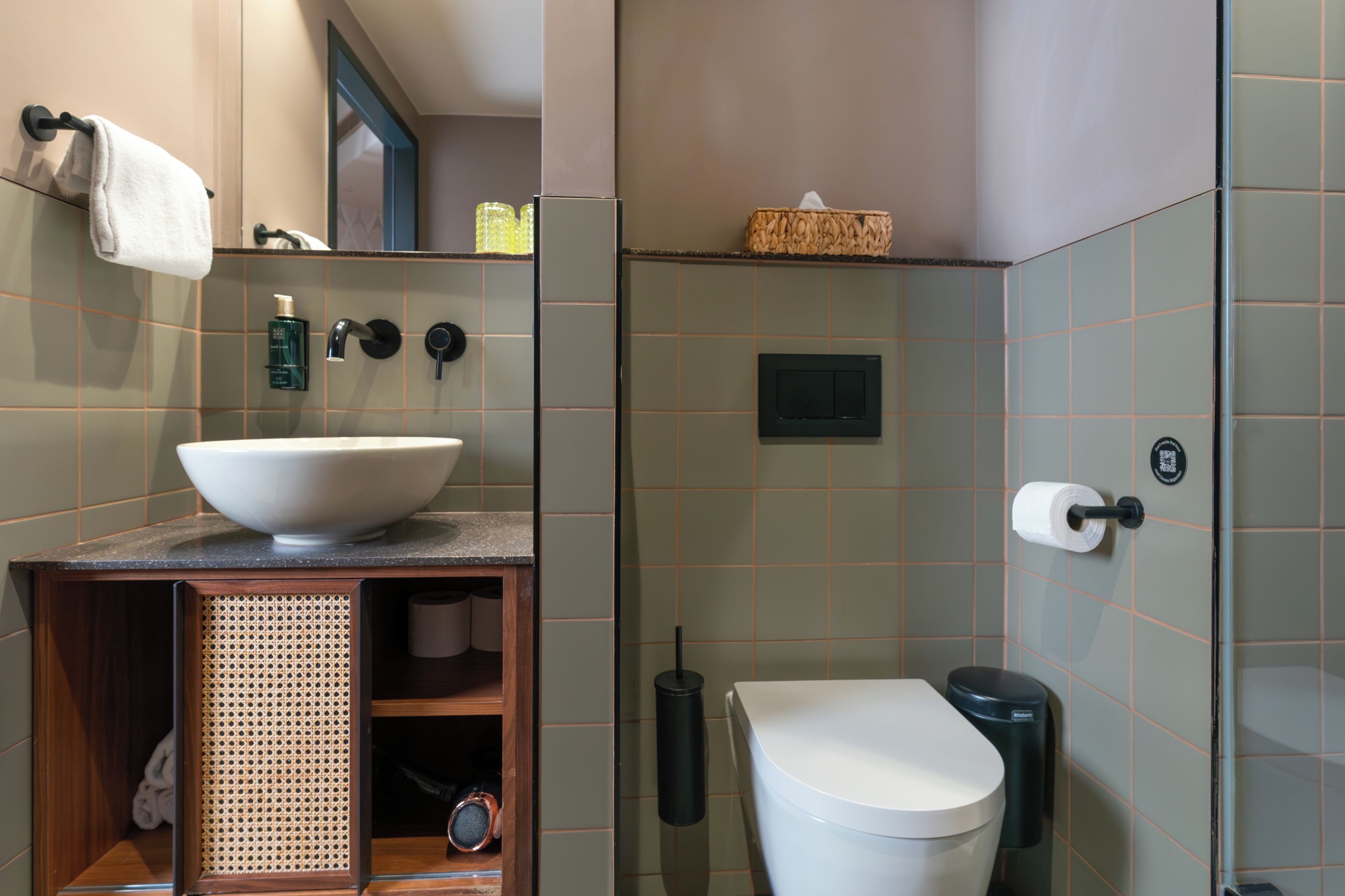 A bathroom with a large sink, toilet, and a shower area.