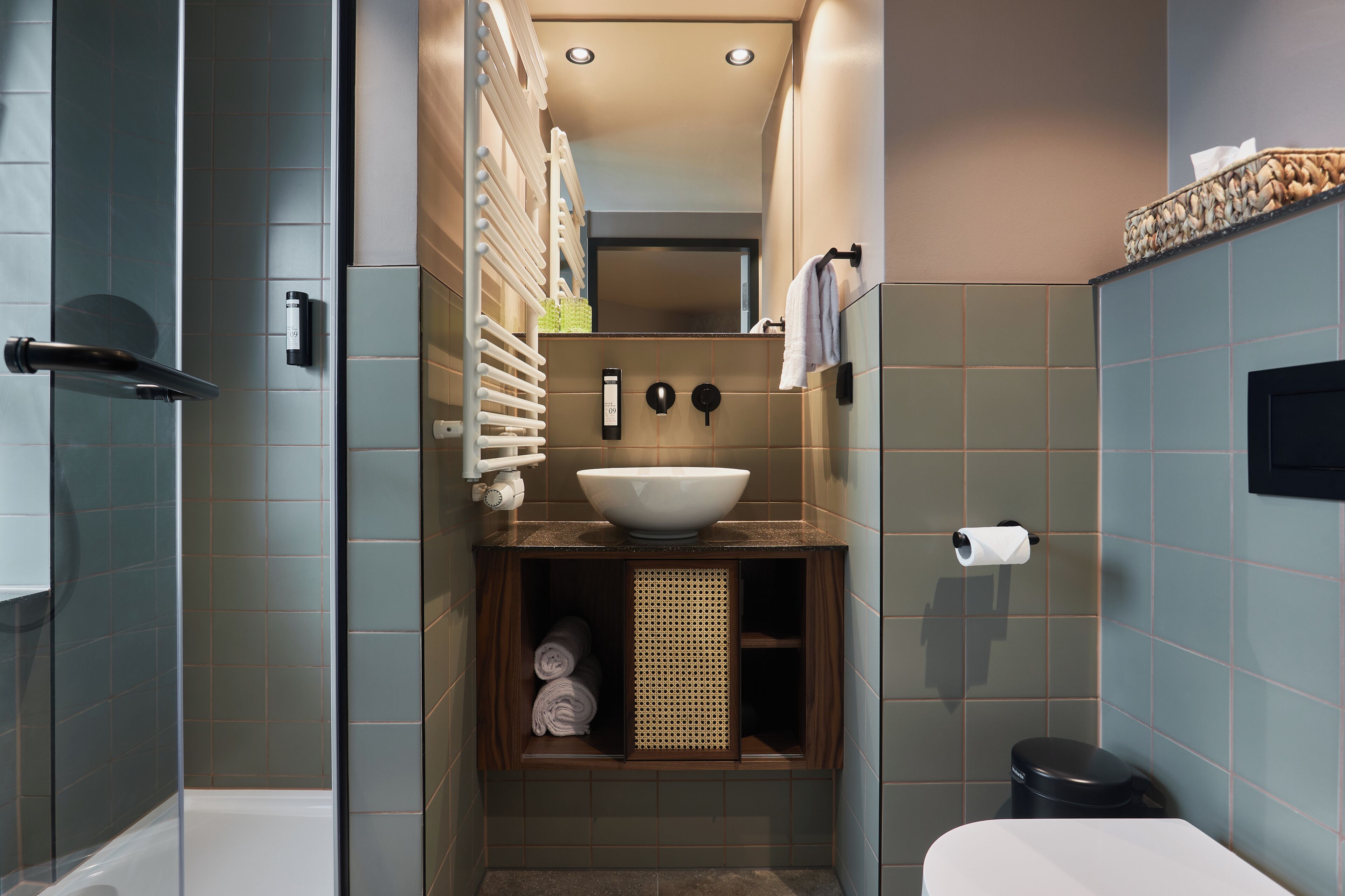 Un baño moderno con lavamanos empotrado, inodoro y zona de ducha.