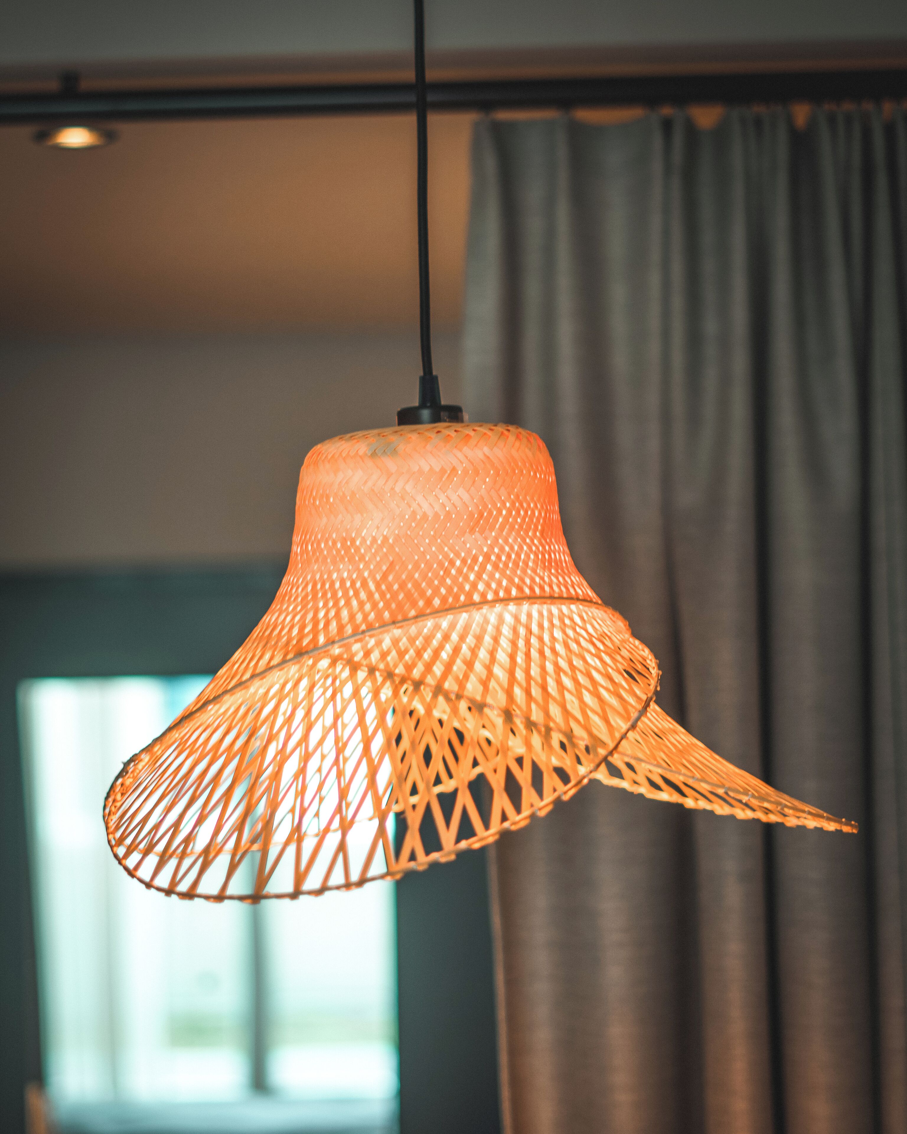 A hanging light fixture with a woven design.